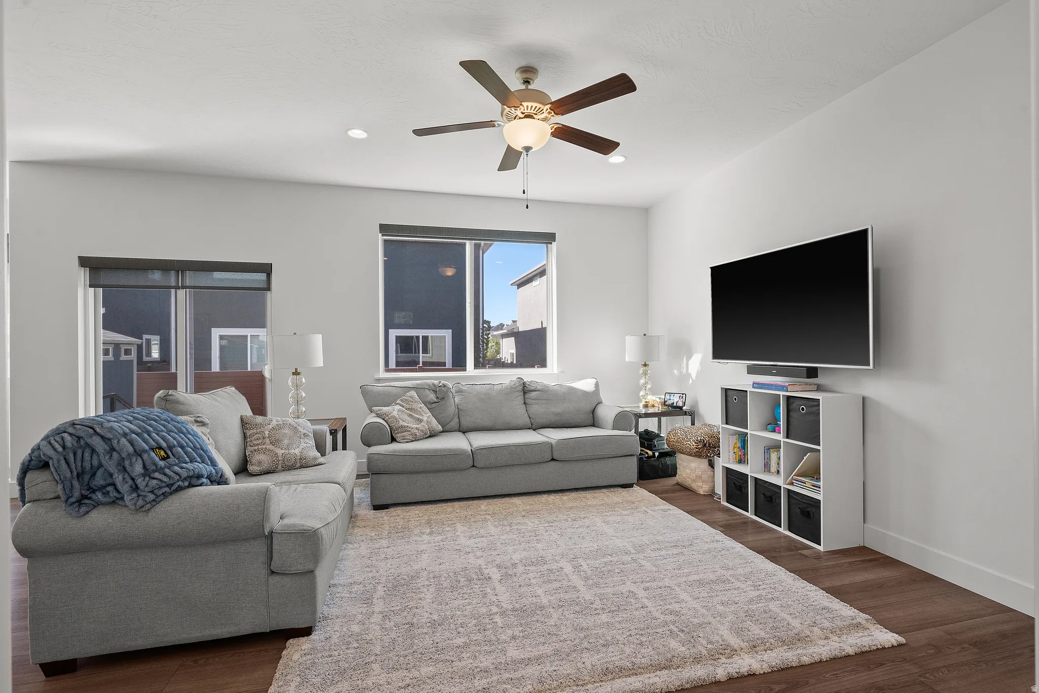Recessed lighting, wood-finish flooring, and a ceiling fan with integrated light fixture