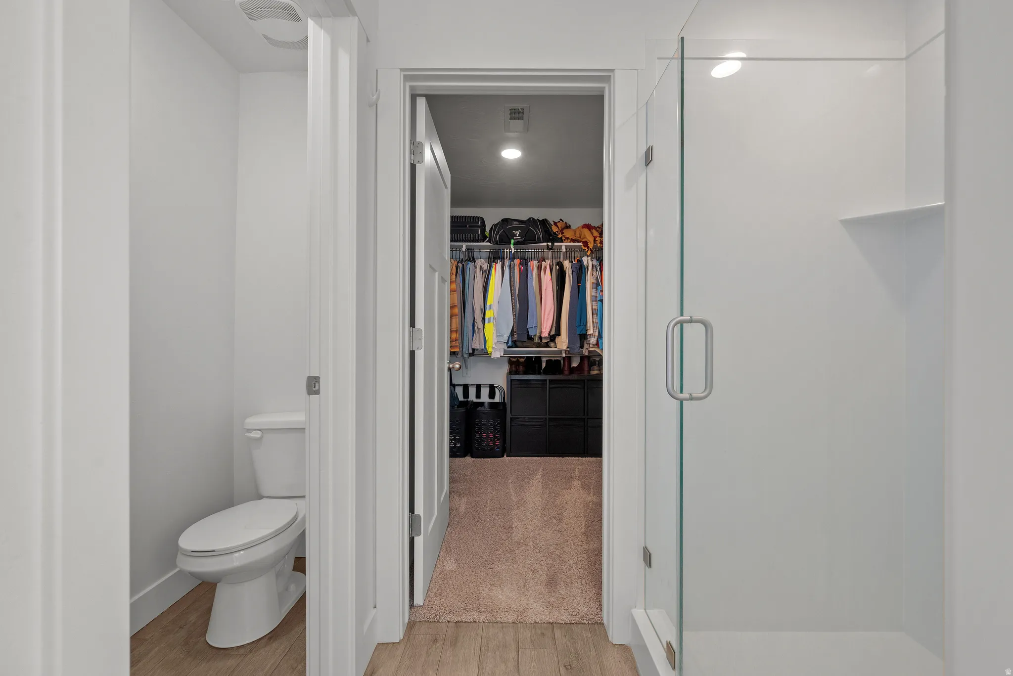 Walk-in shower with clear glass enclosure and built-in shelf