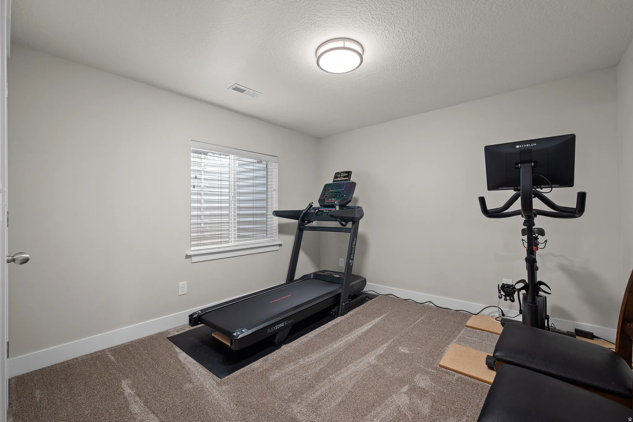 Recessed window with blinds, overhead flush-mount lighting, and neutral wall paint