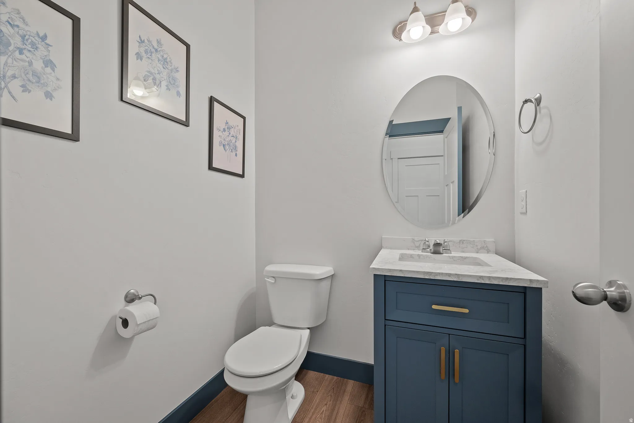 Corner vanity with a white countertop and a circular mirror