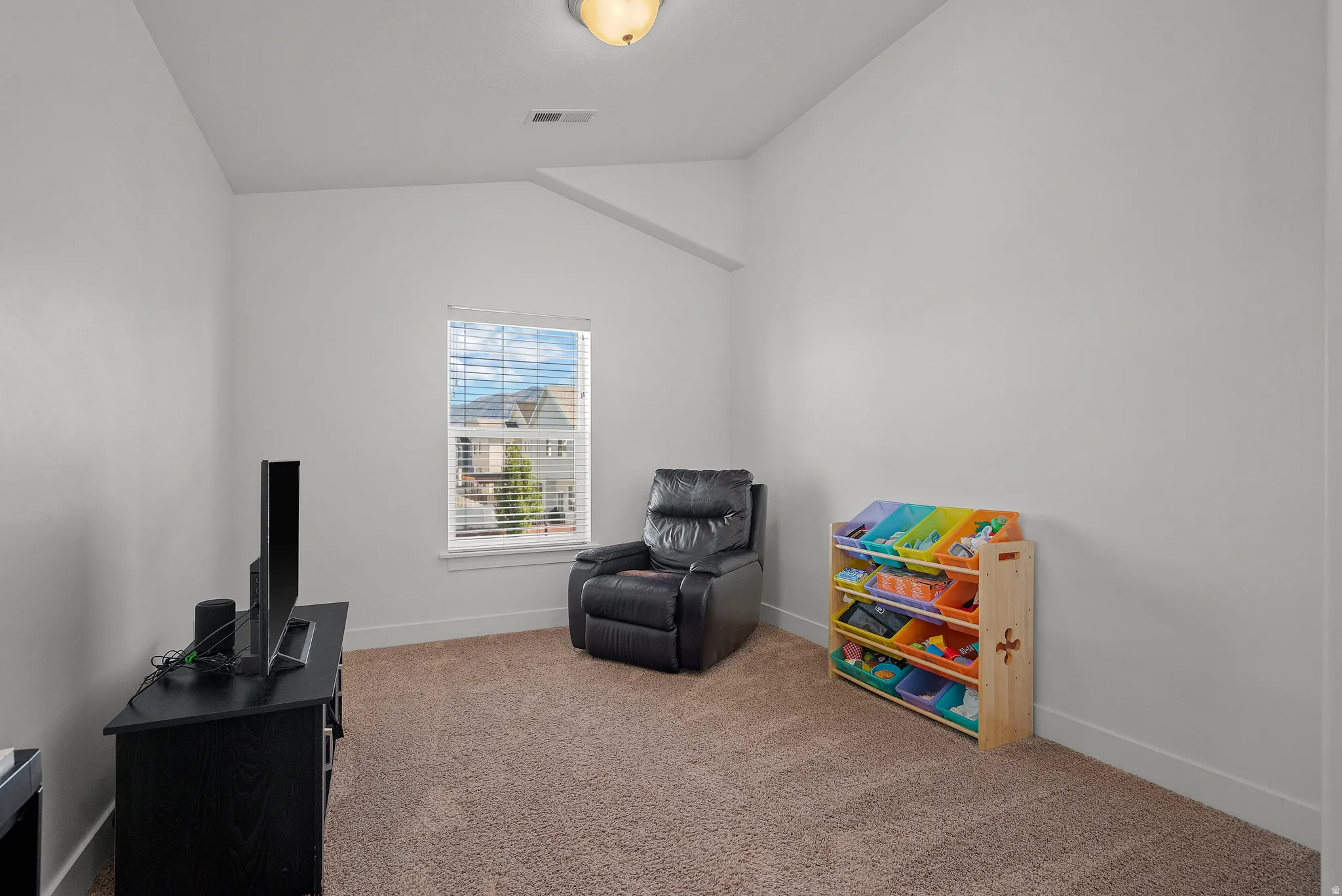 Vaulted ceiling, carpeted flooring, window with blinds, recessed ceiling light
