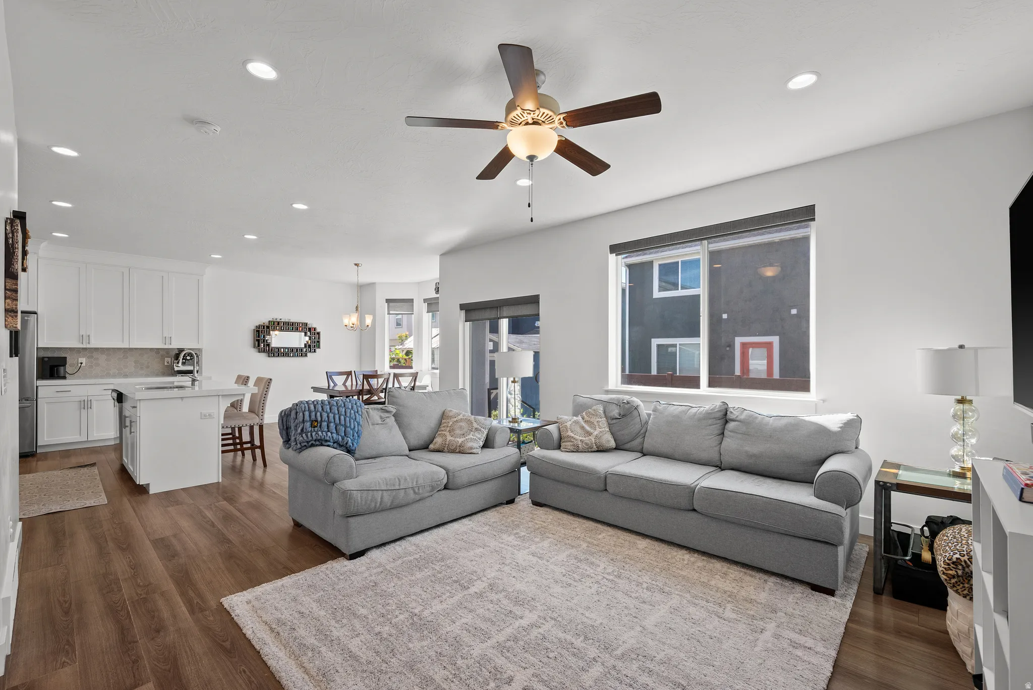 Open-concept living space featuring wood-finish flooring, recessed lighting, and a ceiling fan