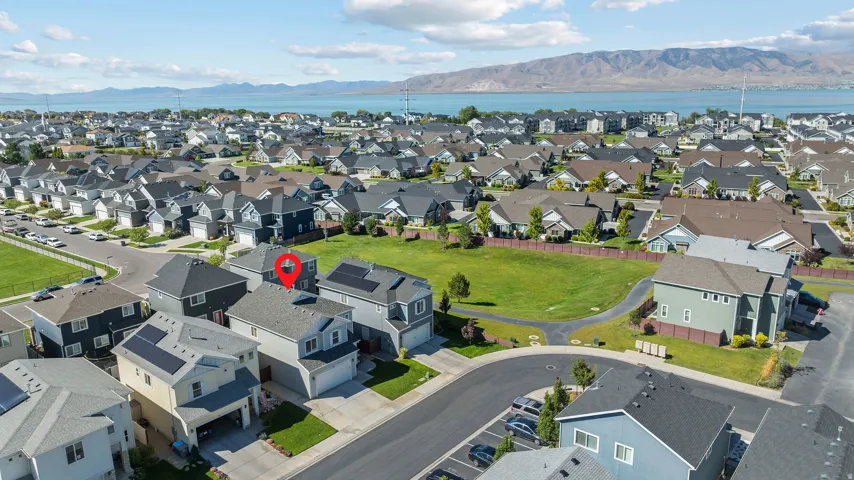 Aerial perspective of a developed residential area with a prominent body of water and mountains in the background