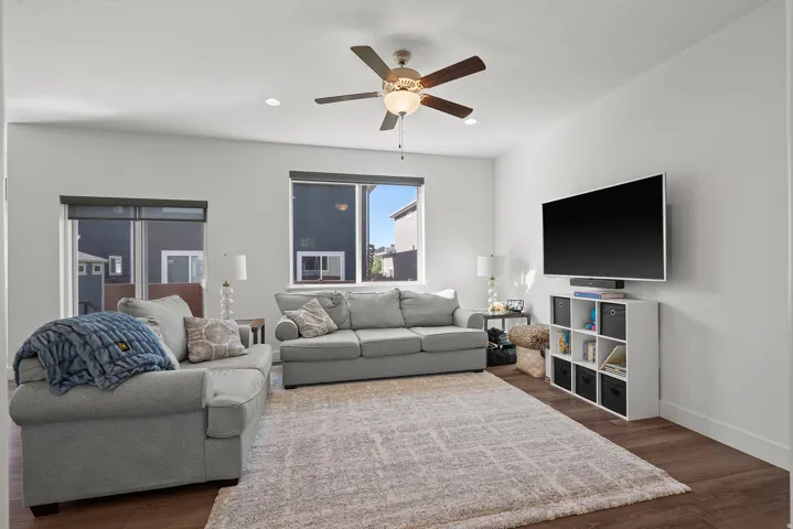 Recessed lighting, wood-finish flooring, and a ceiling fan with integrated light fixture