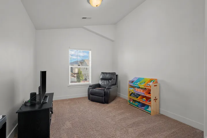 Vaulted ceiling, carpeted flooring, window with blinds, recessed ceiling light