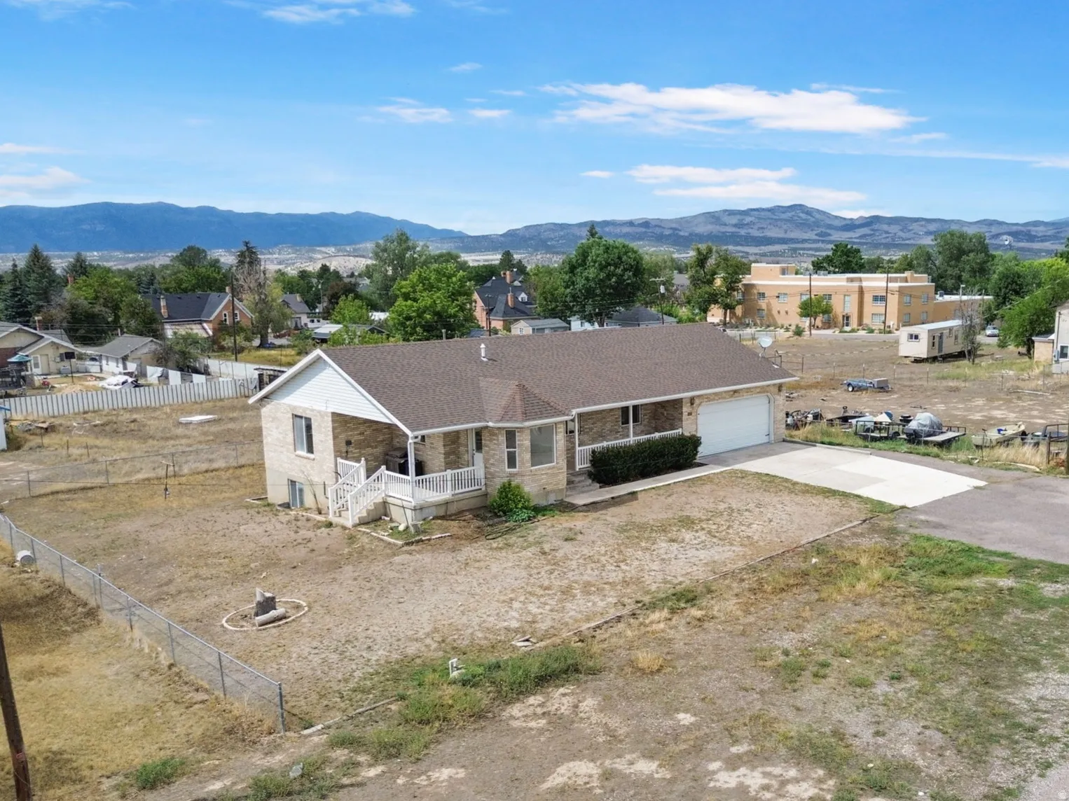 Stone veneer exterior with a covered front porch, attached garage, and mountain scenery