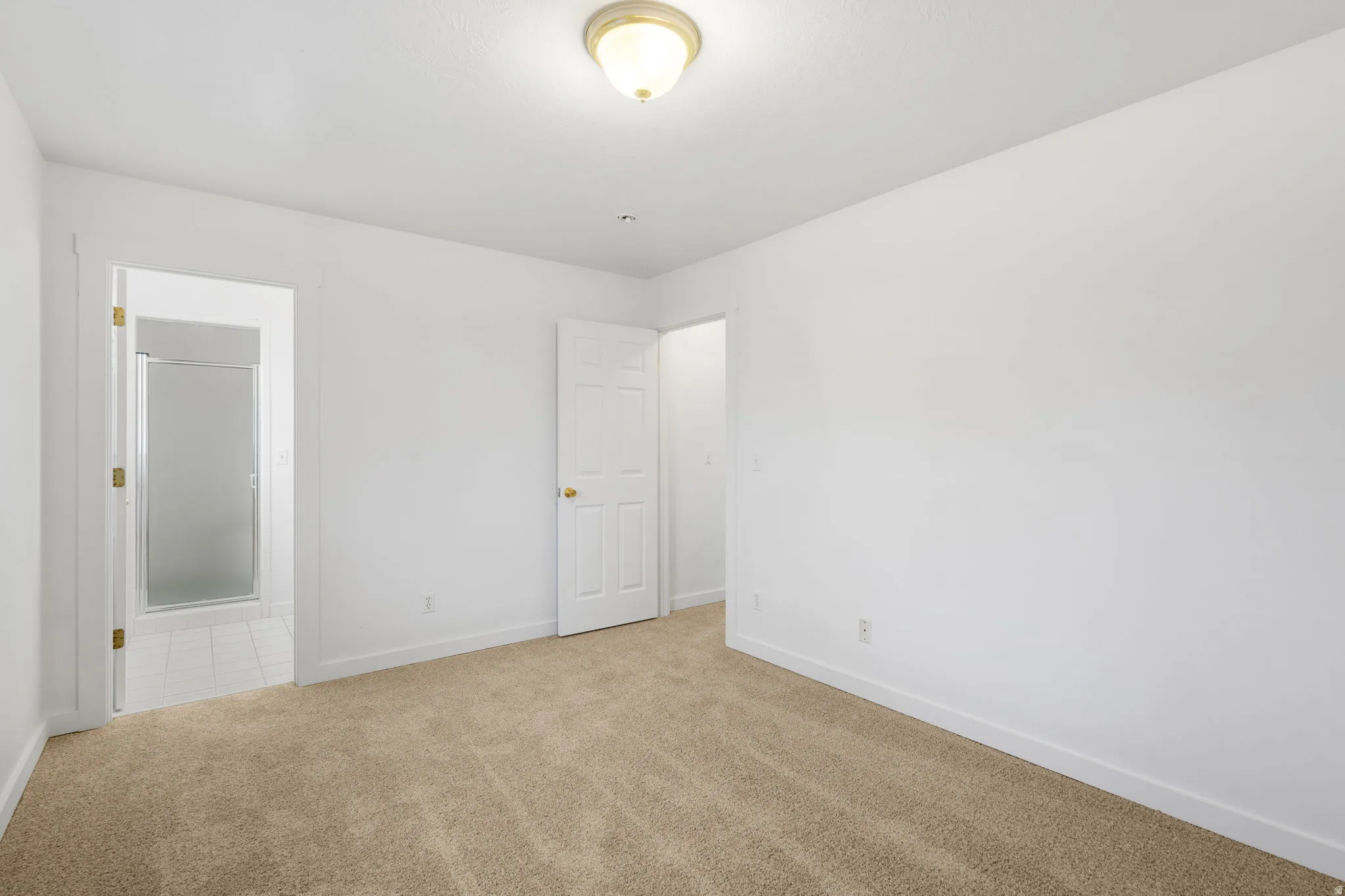 Neutral wall finishes with a ceiling-mounted light fixture