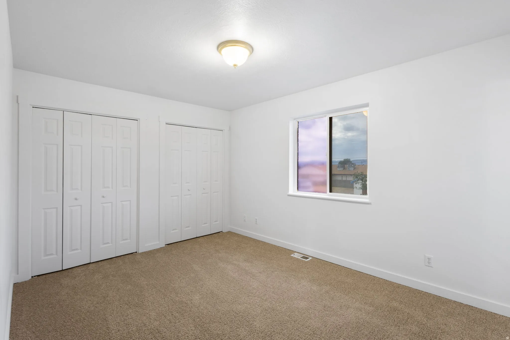 Neutral paint palette with carpet flooring, flush-mount ceiling light, and white trim