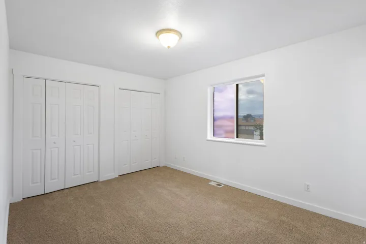 Neutral paint palette with carpet flooring, flush-mount ceiling light, and white trim