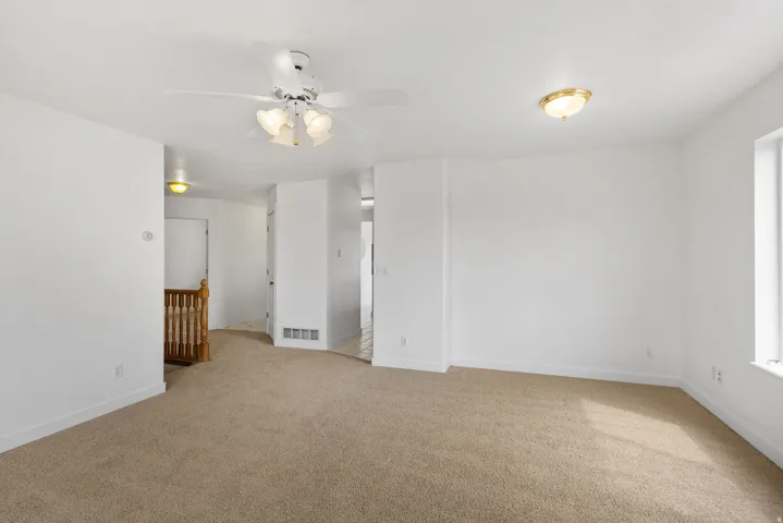 Recessed lighting, ceiling fan, natural light, wall-to-wall carpeting, and wood-finish banister