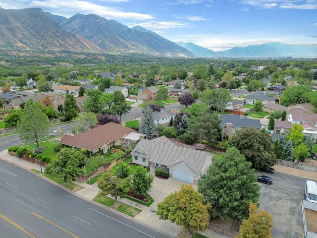 Expansive mountain backdrop with a residential neighborhood featuring mature trees and established landscaping