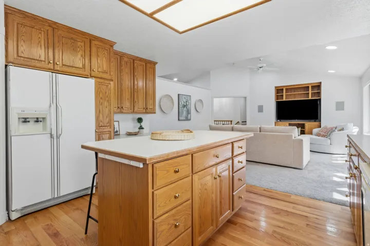 Kitchen island with solid surface countertop, wood-finish cabinetry, and wood-finish flooring