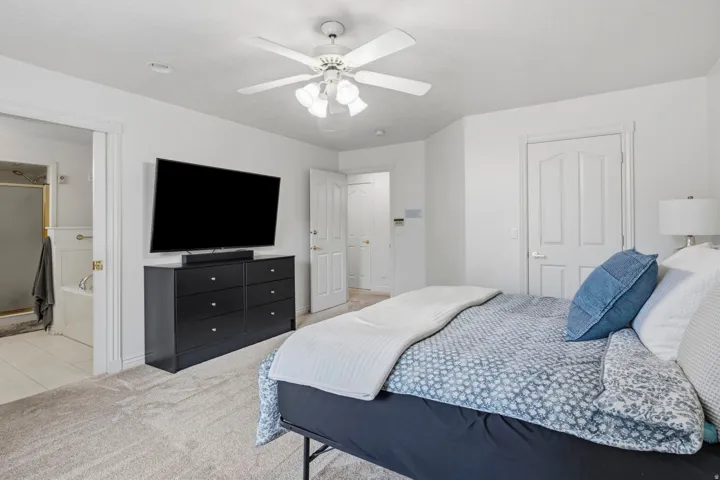 Plush carpet flooring, ceiling fan with integrated lighting, white interior doors, and recessed lighting