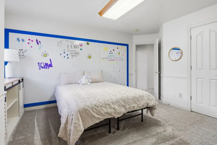 White walls with blue trim, gray carpet flooring, white paneled double doors, white interior door, and a built-in whiteboard wall