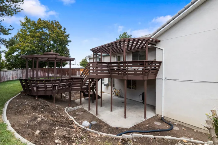 Multi-level wooden deck with pergola and gazebo, providing extensive outdoor living space