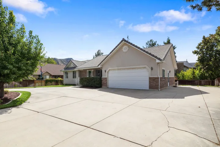 Stucco exterior with brick detailing, attached two-car garage, and a concrete driveway