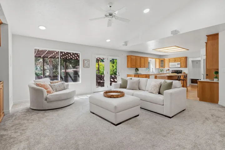 Vaulted ceilings, recessed lighting, and a ceiling fan enhance the living area