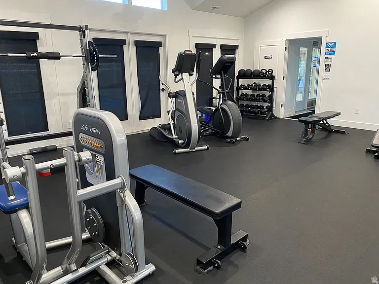 Fitness area featuring vaulted ceilings, recessed lighting, and durable rubber flooring