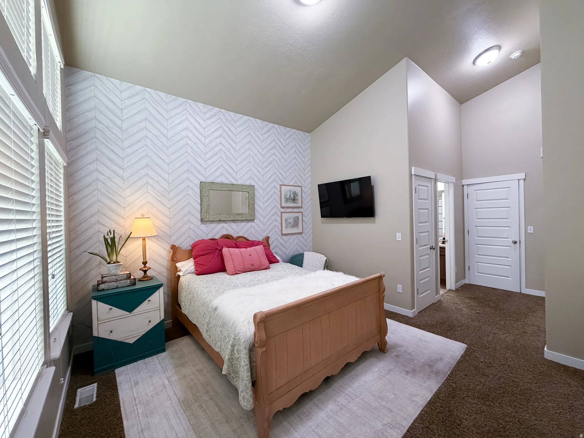 Vaulted ceiling featuring recessed lighting, a chevron pattern accent wall, and a large window with blinds