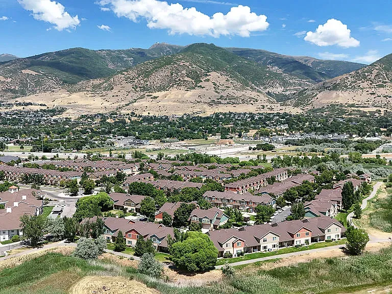 Community residences with mountain backdrop and mature trees