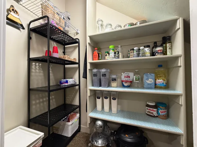 Built-in shelving and a freestanding metal shelving unit provide extensive storage