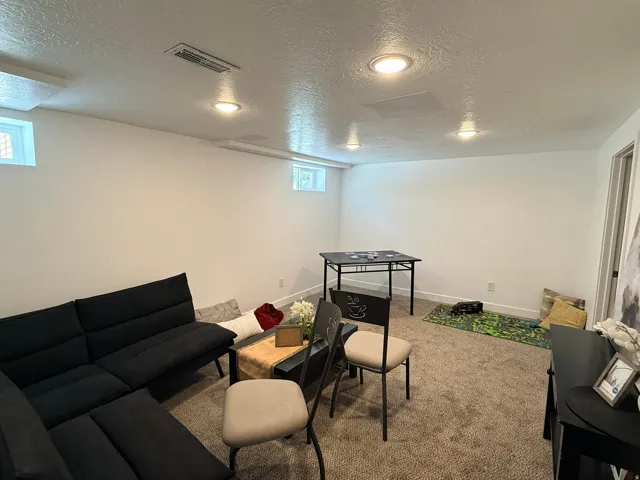 Recessed ceiling lighting, white walls, and carpeted flooring