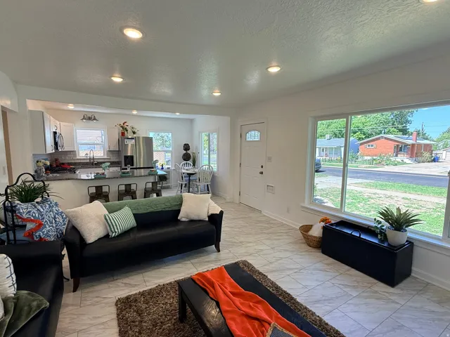 Open-concept living area with recessed lighting, large picture window, and tile flooring