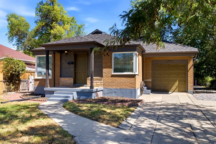 Brick exterior with covered front porch, attached garage, and concrete driveway