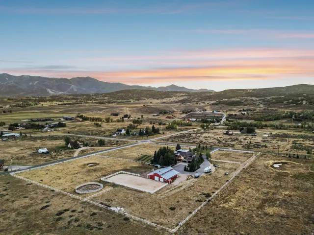 Expansive property featuring a residence, detached garage, and a riding arena, all set within a fenced perimeter