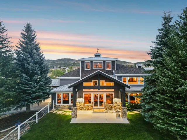 Multi-level siding exterior featuring a gable roof, integrated cupola, and a spacious rear patio