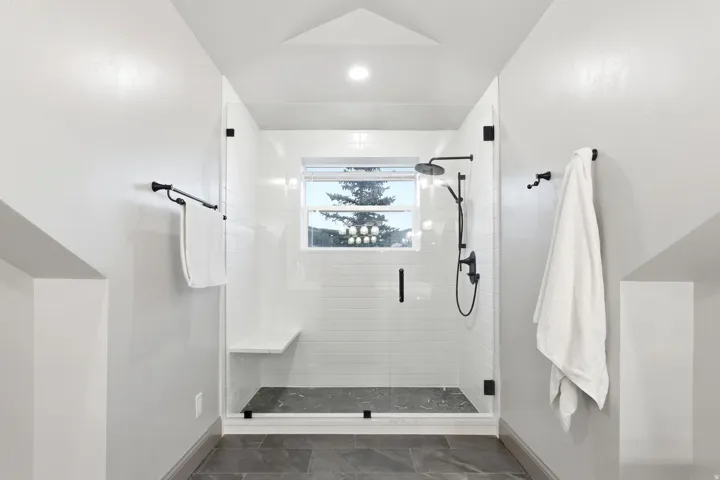 Walk-in shower with clear glass enclosure and black hardware