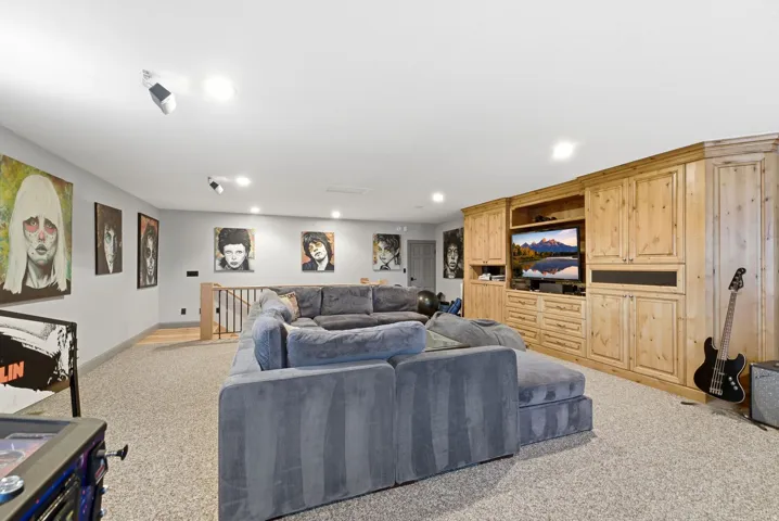 Built-in entertainment center featuring extensive wood cabinetry, recessed lighting, and track lighting