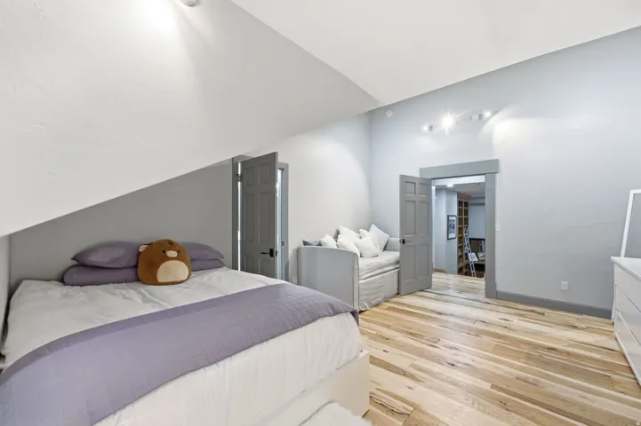 Hardwood flooring throughout, recessed lighting, and a paneled door