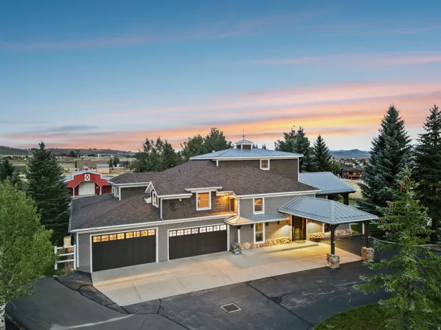 Contemporary residence featuring a multi-car garage, covered entry, and a large paved driveway