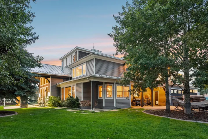 Multi-level exterior with gray siding and stone accents, featuring a metal roof