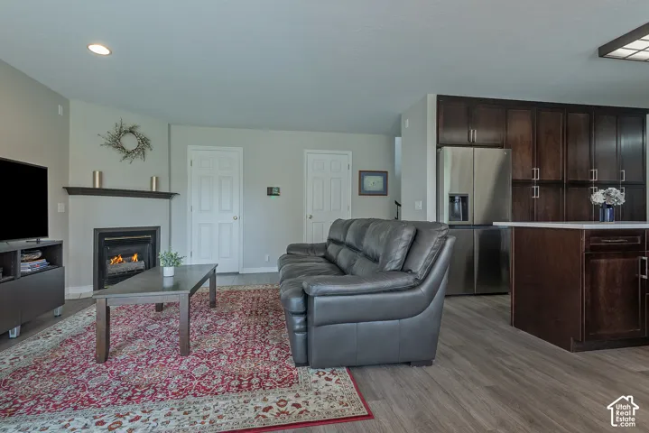 Living area featuring a fireplace with a dark mantel, light-toned walls, and wood-finish flooring