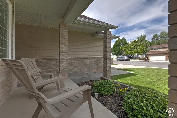Covered porch entry featuring brick pillars and a concrete surface