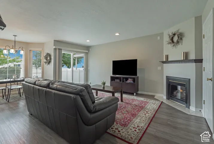 Living area featuring wood-finish flooring, a corner fireplace with a dark wood mantel, and recessed lighting