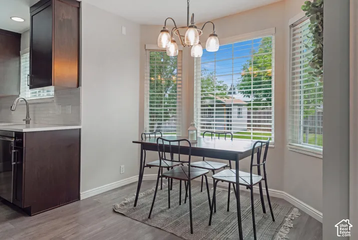 Bay window dining area with a modern chandelier and wood-finish flooring