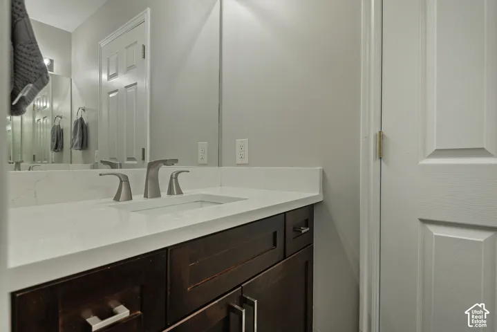 Bathroom vanity with a rectangular undermount sink, brushed nickel faucet, and a light-toned countertop