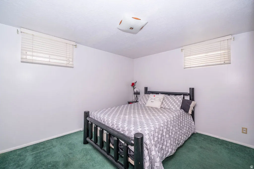 White walls with a textured ceiling, a flush-mount ceiling light, and two horizontal windows with blinds