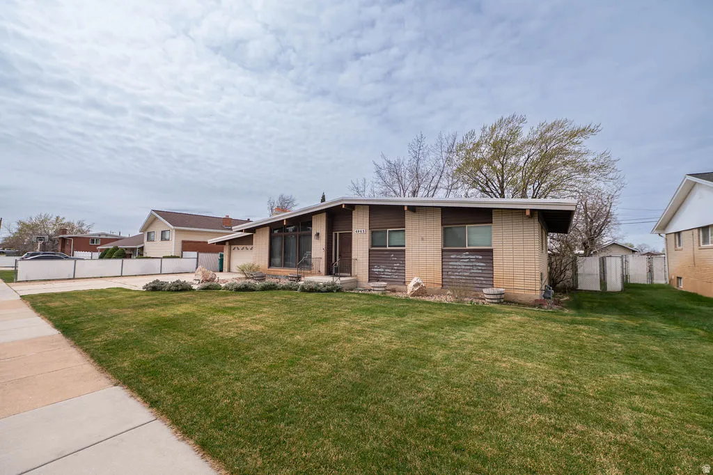 Single-story residence featuring a well-maintained lawn and established landscaping