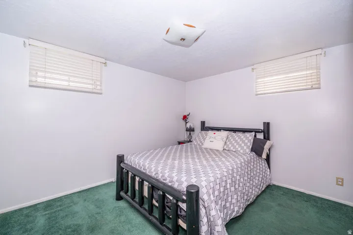 White walls with a textured ceiling, a flush-mount ceiling light, and two horizontal windows with blinds
