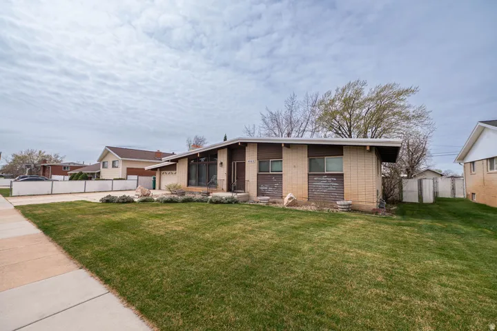 Single-story residence featuring a well-maintained lawn and established landscaping