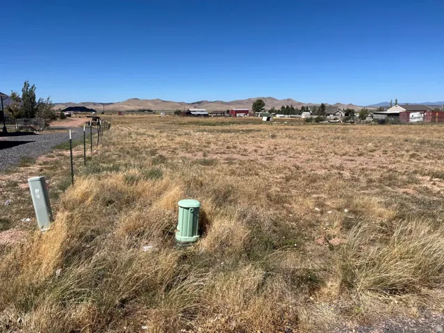 Expansive open land featuring natural vegetation and distant mountain ranges