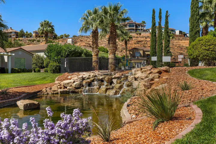 Landscaped grounds featuring a tranquil pond with a rock waterfall