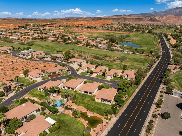 Residential development featuring a community pool, surrounding golf course, and a pond