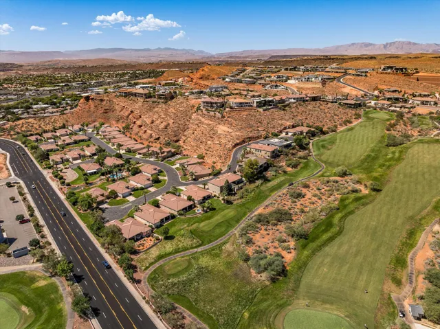 Golf course frontage, residential community, paved roadways, desert landscaping, mountain backdrop