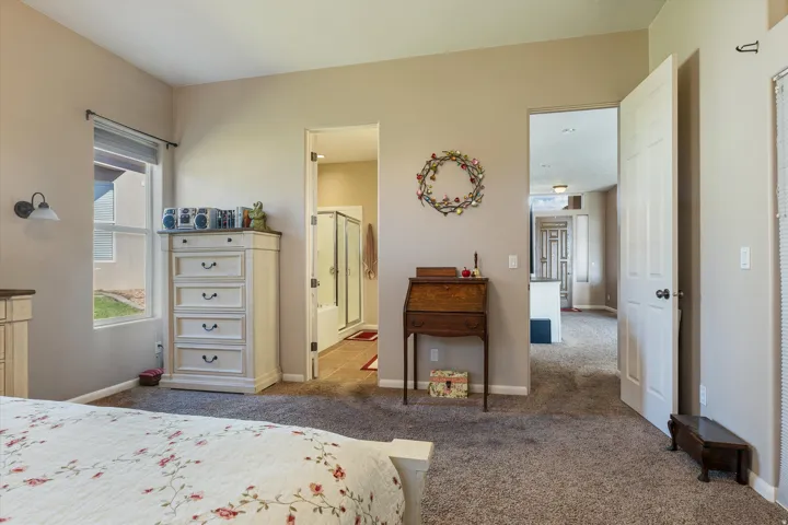 Carpeted interior with light-colored walls, window with blinds, and white paneled doors