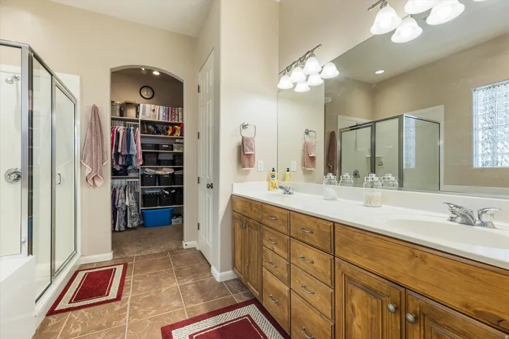 Dual vanity with integrated sinks, wood-finish cabinetry, and a full-width mirror